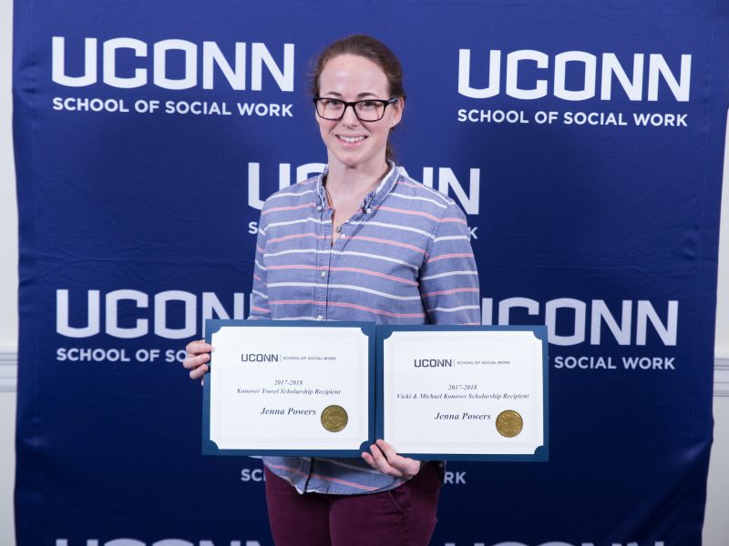 Doctoral Student Jenna Power holding scholarship certificates