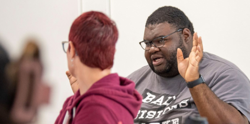 student walking across the front of the school of social work building
